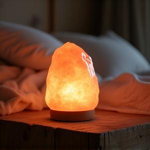 Warm glowing Himalayan Salt Lamp on a bedside table